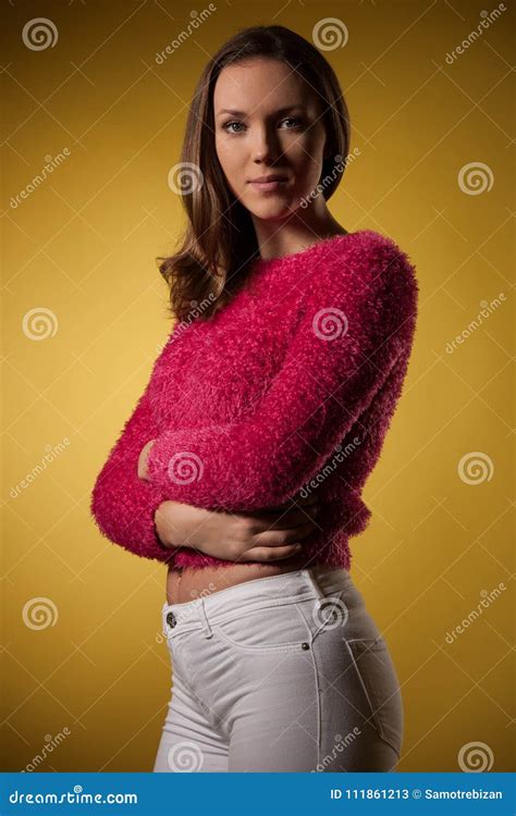 Portrait Of A Beautiful Young Woman In Pink Sweater Over Yellow Stock