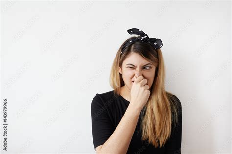 Female Gesture Smells Bad Portrait Of Woman Wearing Casually Pinches