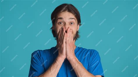 Free Photo Excited Man Covering Mouth Hands Looking Happy Over Blue