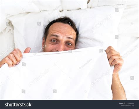 Scared Man Hiding Bed Under White Stock Photo 1339143404 Shutterstock