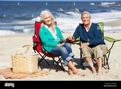 Couple Assis En Riant Sur Une Chaise De Plage Banque De Photographies