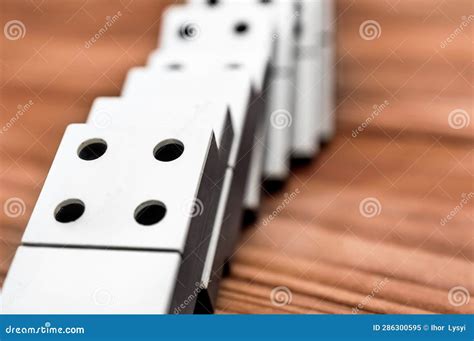 Row Of Falling Dominoes On The Wooden Table Copy Space Stock Image