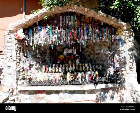 Offerings Of Crucifixes And Candles In A Small Man Made Grotto At El