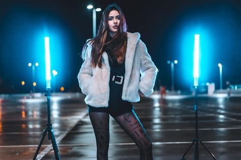 Premium Photo Pretty Caucasian Brunette In A Pink Wool Jacket In An Empty Car Park Illuminated