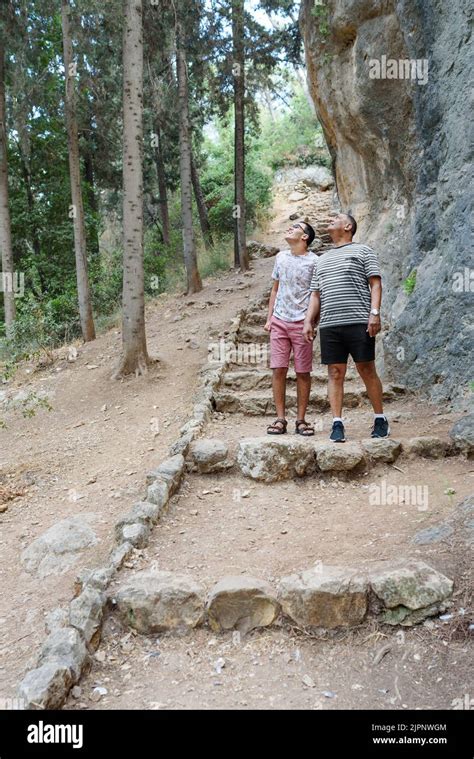 Un fils adolescent heureux et un père senior qui marchent dans les bois