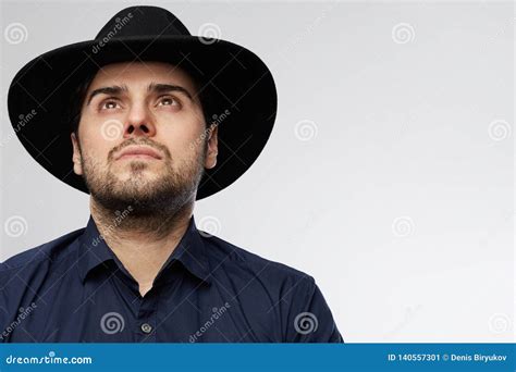 Confident Handsome Hispanic Man Wearing Black Hat Looking Up Isolated