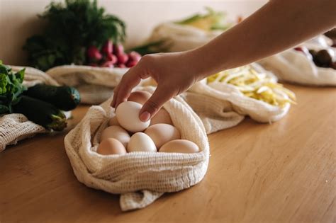 Mano Femenina Toma El Huevo De La Bolsa De Lona Verduras En Bolsas De