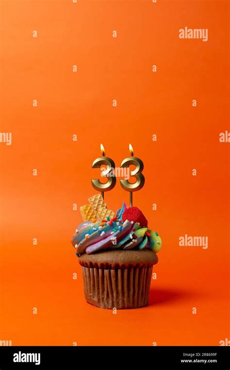 birthday cake with number 33 - cupcake on orange background with ...