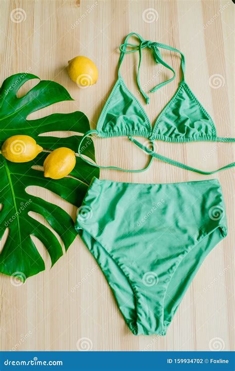 Bright Trendy Bikini On A Wooden Background With Yellow Lemons