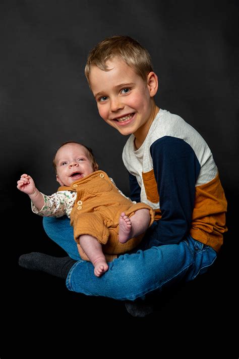 Photo Dun Enfant Qui Tien Son Petit Frere Dans Ses Bras En Studio