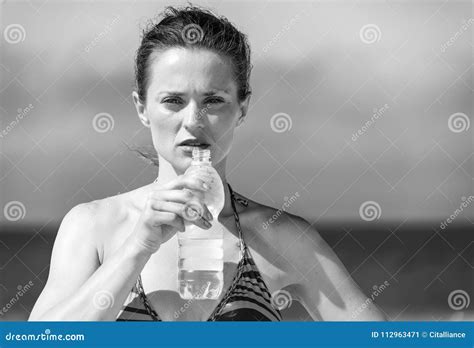 Retrato De La Mujer Moderna En Bikini En El Agua Potable De La Playa Imagen De Archivo Imagen