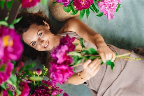 Attractive Brunette Nude Breast Woman With A Bouquet Of Peonies On The Bed Stock Photo Image