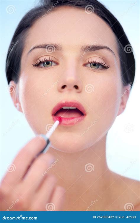 Pretty In Pink A Young Woman Applying Pink Lipstick With An Applicator