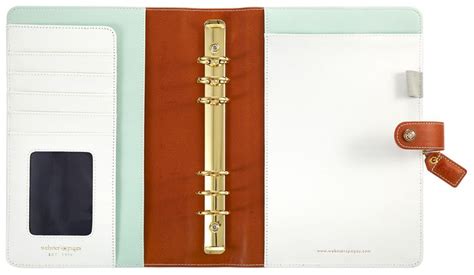 A White And Brown Binder With A Gold Pen On The Front An Orange