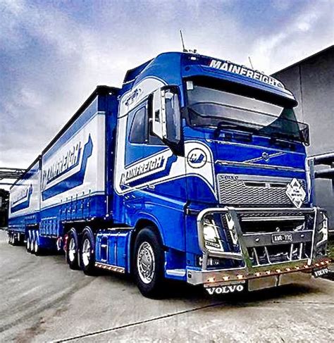 A Blue Semi Truck Parked In Front Of A Building