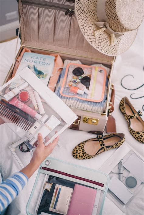 An Open Suitcase Sitting On Top Of A Bed Next To Shoes And Other Items