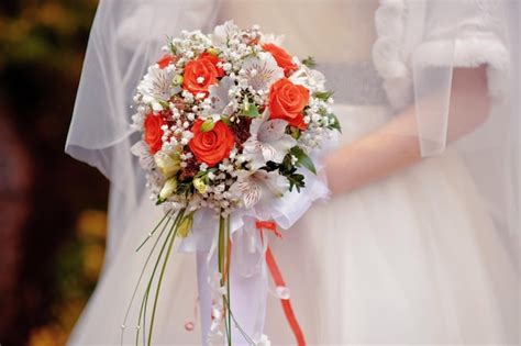 Novia Sosteniendo Un Ramo De Novia Con Flores Blancas Y Rojas Foto