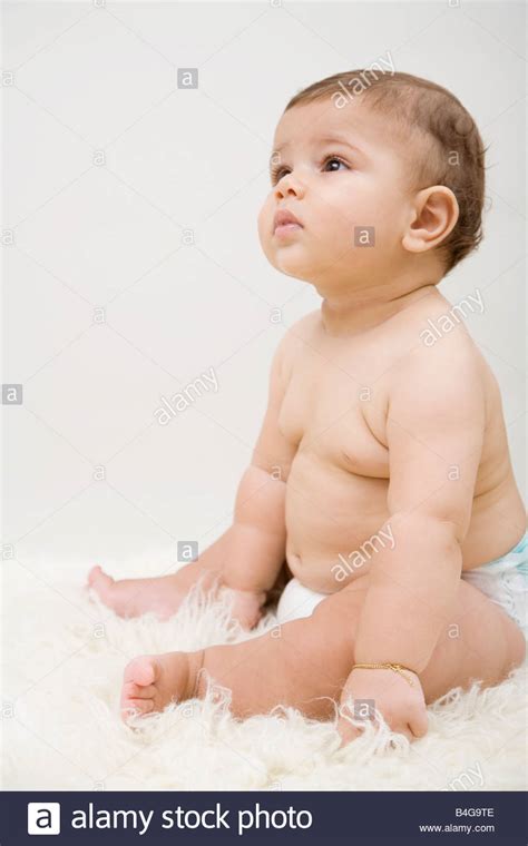 A Baby Boy Sitting On A Sheepskin Rug Stock Photo Alamy