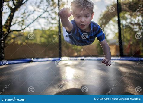 Cute Little Boy Jumping On The Trampoline Like A Superhero People