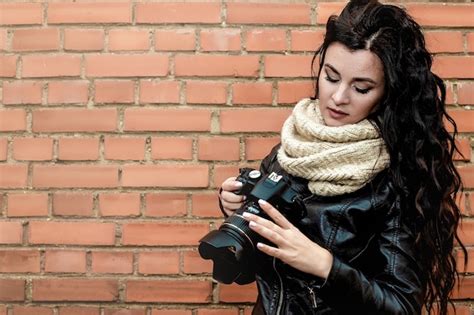 Premium Photo Portrait Of A Beautiful Brunette Girl Photographer With Long Curly Hair In Warm
