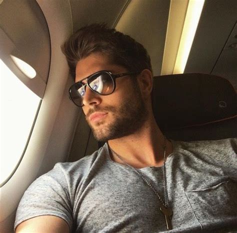 A Man Wearing Glasses Sitting In An Airplane