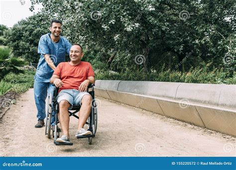 Mens Die In Rolstoel Met Zijn Verpleegster Bij Park Lachen Stock Foto Image Of Draag