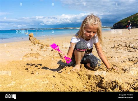 Une Magnifique Petite Fille Blonde De Creuser Un Trou Sur La Plage Avec Un Chat Au Magnifique