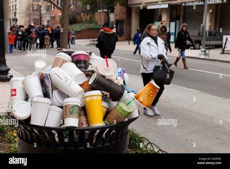 Discarded Coffee Cups Overflowing From Public Trash Bin Stock Photo