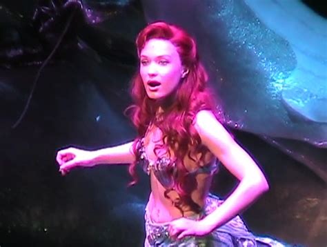 a woman with red hair is standing on stage