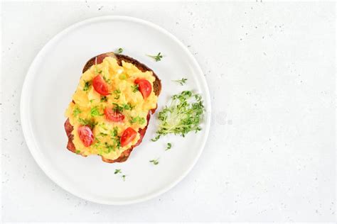 Scrambled Eggs With Microgreen And Tomatoes On Bread Stock Photo