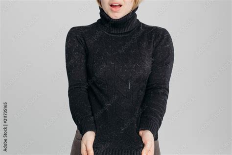 Crop Of Shocked And Unhappy Incognito Blonde Woman Showing Her Dirty Black Sweater At Camera