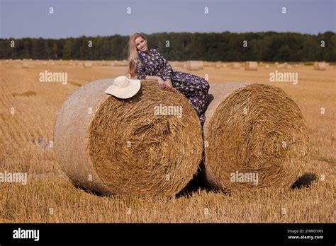 Une Jeune Fille Blonde Aux Cheveux Longs Dans Un Chapeau Blanc Se Repose Et Pose Pr S Des Gerbes