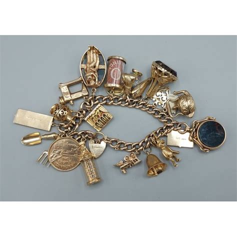 A 9ct Gold Charm Bracelet Set With Many Charms To Include Two Fob Seals