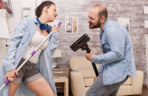 Pareja Limpiando La Casa Y Cantando En La Aspiradora Foto Gratis