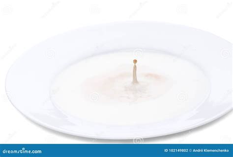 Milk Splash From A Falling Cocoa Drop Into A Plate With Milk Horizontal Close Up Image