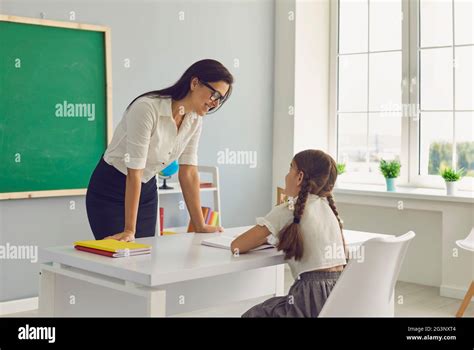 Une Jeune Enseignante Et Une Jeune élève De L école élémentaire Parlent En Classe Photo Stock