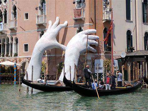 Venice, two giants hands support the city against climate change