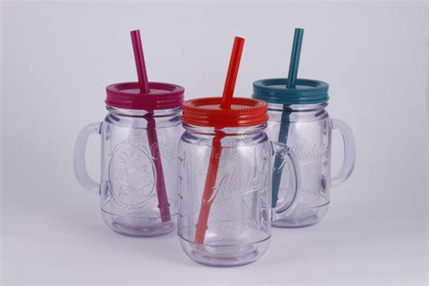 Plastic Transparent Mason Jar Cups with Colored Cover and Large Plastic Straws Stock Photo ...