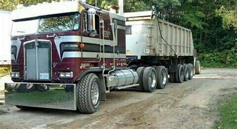 A Large Semi Truck Driving Down A Dirt Road