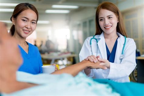 Premium Photo | Smiling female doctor and nurse looking at patient in ...