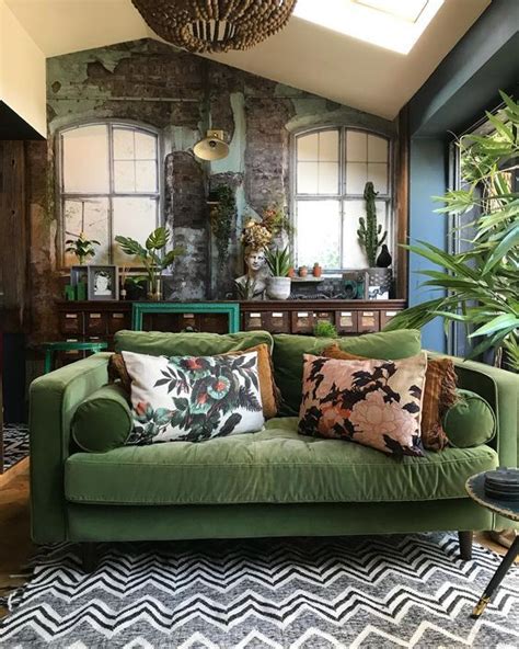 A Living Room With Green Couches And Pillows On The Floor Next To