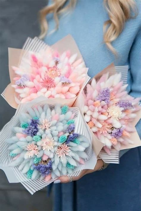 A Woman Holding Two Bouquets Of Flowers In Her Hands And Wearing A Blue