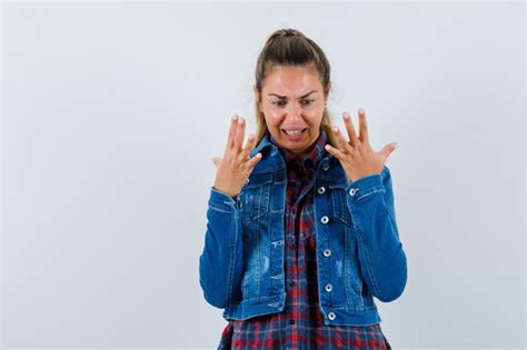 Jeune femme en chemise veste levant les mains et regardant en colère