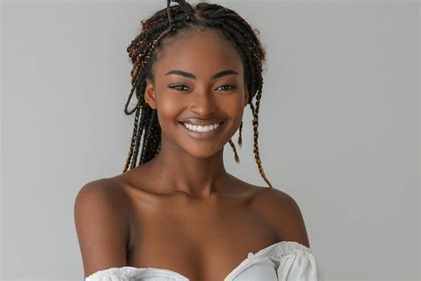 Portrait Of Smiling Black Woman With Braids Wearing A White Top And