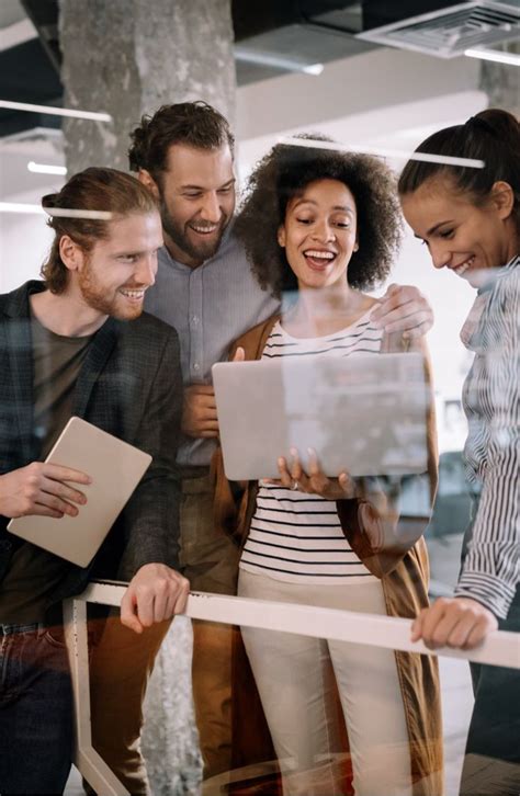 Group Of People Standing Around Each Other Looking At Something On A