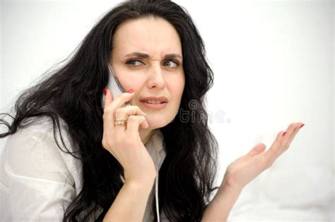 Dissatisfied Brunette Talking On The Phone She Shows Her Hand To The Side Wrinkle Her Forehead