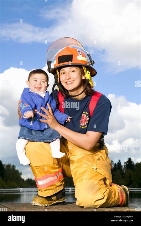 Portrait Of Female Firefighter Holding Baby Stock Photo Alamy