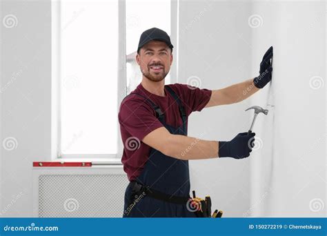 Handyman In Uniform Working With Hammer Professional Construction