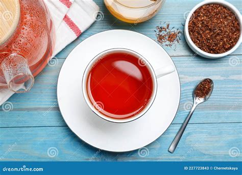 Freshly Brewed Rooibos Tea And Dry Leaves On Light Blue Wooden Table