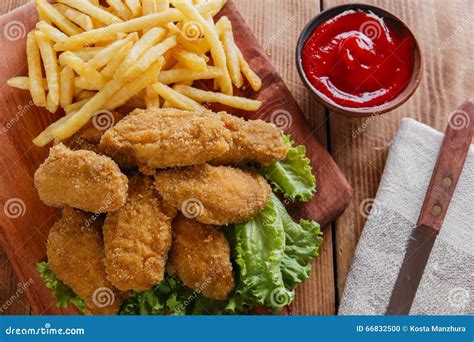 Chicken Wings Fried in Breadcrumbs with Sauce and French Fries Stock